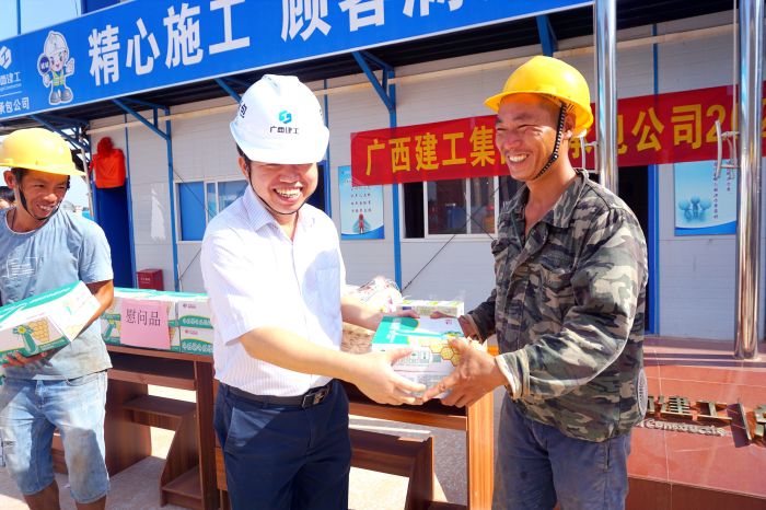 岑廷义为工人发放清冷慰问品。谢微旋 摄.jpg